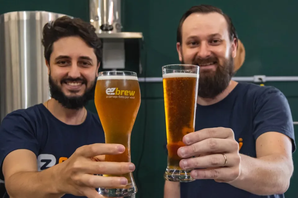 Os dois sócios da EZbrew brindando com cervejas