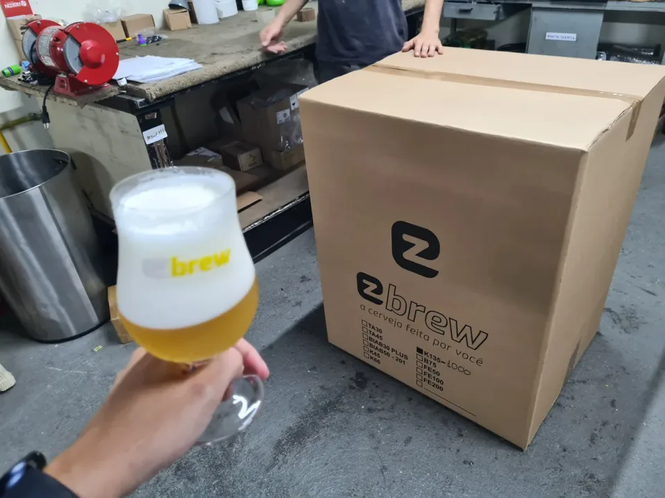 Cerveja servida ao lado de uma caixa de expedição da EZbrew