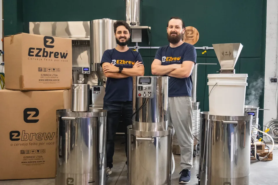 Os sócios da EZbrew ao lado dos equipamentos e das caixas de expedição